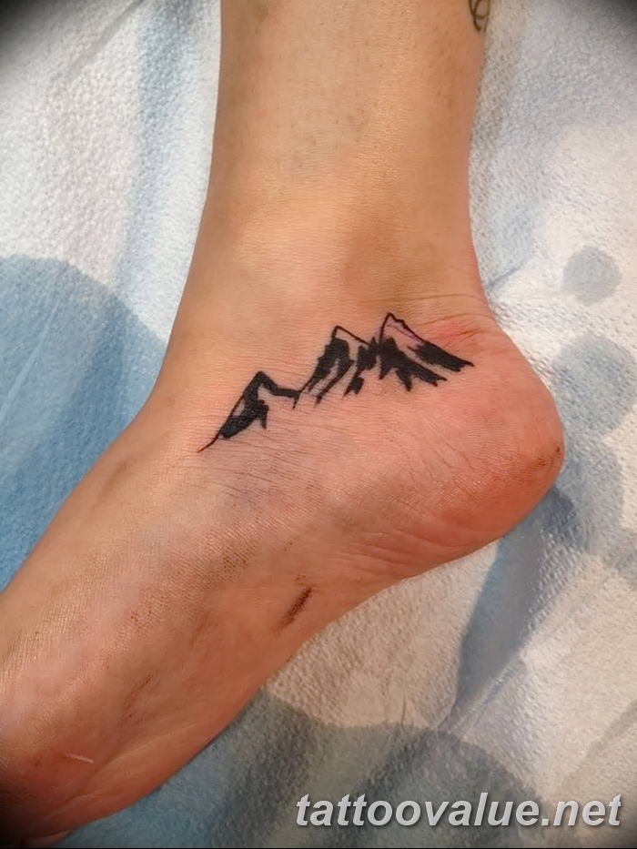Mountain tattoo on the right inner forearm