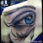 Color tattoo of a hyperrealistic blue eye with feathered tears and claw-like markings on the shoulder. Detailed shading and emotional expression.