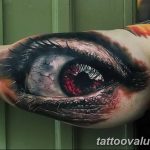 Realistic tattoo of a cracked, red eye on a bicep, showcasing intense shading and detail. A striking ink idea for those seeking symbolic tattoo art.