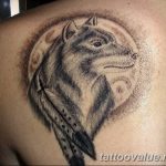 Black and grey wolf tattoo with a full moon backdrop on the shoulder. Detailed fur texture and a dreamlike, ethereal quality.