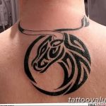Black tribal tattoo of a bull's head within a circular design, placed on the back of the neck, showcasing bold lines and geometric patterns.