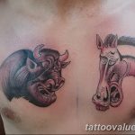 Black and grey tattoo of a bull and horse head facing each other on the chest. A bold and symbolic tattoo design.