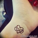 Small, delicate black ink infinity symbol forming a heart shape on the wrist. A minimalist and romantic tattoo design.