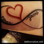 A colorful tattoo featuring an infinity symbol forming a heart shape, with the names 'Ethan' and 'Jacob' inscribed along the loops. Vibrant and sentimental.