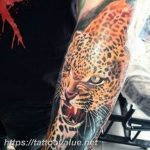 Colorful leopard head tattoo on the forearm, featuring orange and black fur with fiery accents and whisker details.