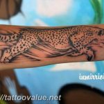 Blackwork cheetah tattoo running along the forearm, showcasing sleek lines and a dynamic pose, in a minimalist style.
