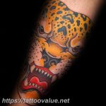Colorful neo-traditional jaguar head tattoo on a man's arm, featuring bold lines, vibrant colors, and detailed shading.