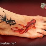 Two koi fish tattoo on a foot, one black and one orange, with flowing fins and detailed scales, showcasing a watercolor-inspired style.
