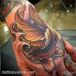 Detailed koi fish tattoo on the back of the hand, featuring traditional Japanese waves and bold black outlines. A unique tattoo design for a striking look.