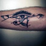 Unique forearm tattoo featuring a deconstructed Eye of Horus with geometric shapes and dotwork shading.