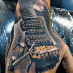 Realistic black and grey tattoo of an electric guitar covering a hand, showcasing detailed shading and instrument design. A bold tattoo idea for music lovers.