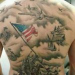 Large back tattoo featuring American flags, WWII aircraft, and soldiers in a realistic black and grey style. A powerful tribute to military service.