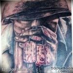 Black and grey realism tattoo of a soldier in uniform, wearing a hat and displaying dog tags, on the shoulder.