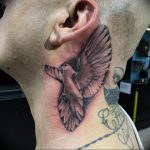 Realistic black and grey dove tattoo on the neck, with wings spread. Detailed feather work, bold placement, popular ink ideas.