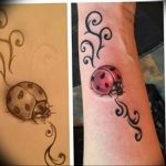 Ladybug tattoo with a swirling, decorative trail, showcasing a blend of realism and ornamental design on the forearm. A delicate and artistic tattoo.