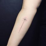 A delicate, black linework tattoo on the forearm depicting a star with a dotted line trailing behind it, representing a shooting star.