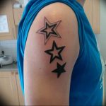 Simple black tattoo of three stacked stars on the upper arm, featuring bold outlines and a minimalist design. A classic and understated tattoo art.