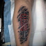 Black and grey biomechanical tattoo on a forearm, depicting a lightsaber hilt emerging from torn skin with mechanical details.