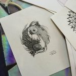 Detailed pencil sketch of two koi fish forming a yin yang symbol, with floral accents, likely a tattoo design draft.