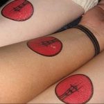 Three matching tattoos of red guitar picks with black detailing, displayed on the inner forearms of multiple people.