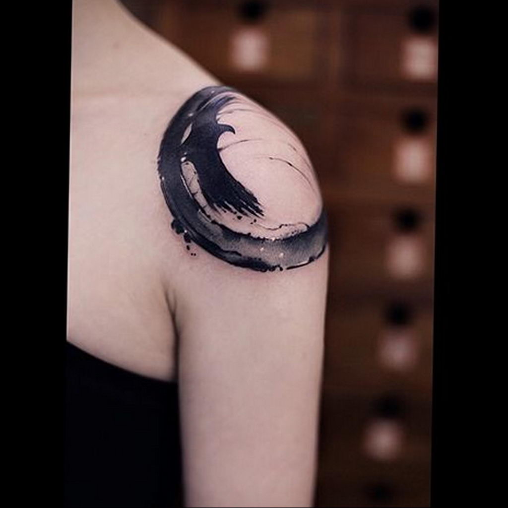 Abstract circle tattoo on the left shoulder