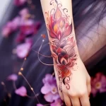 A vibrant lotus flower tattoo with a fiery color palette and intricate ornamental details, beautifully placed on the forearm. This tattoo art showcases stunning ink ideas for floral designs.