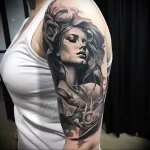 A detailed black and grey tattoo on a shoulder, featuring a beautiful woman's portrait adorned with roses, showcasing realism and delicate shading.