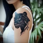 What are the best ink colors for tattoos - A woman with a sleek black panther tattoo style r ca e bc cad - 030124 tattoovalue.net 287