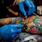 What are the best ink colors for tattoos - An artist working on a detailed and colorful sleeve fcadd bb f a deee - 030124 tattoovalue.net 313