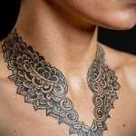 Detailed black ink mandala tattoo on a woman's neck and upper chest. Intricate patterns and symmetrical design create a captivating image.