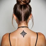 A small, delicate blackwork tattoo at the base of a woman's neck, showcasing minimalist design and subtle placement.